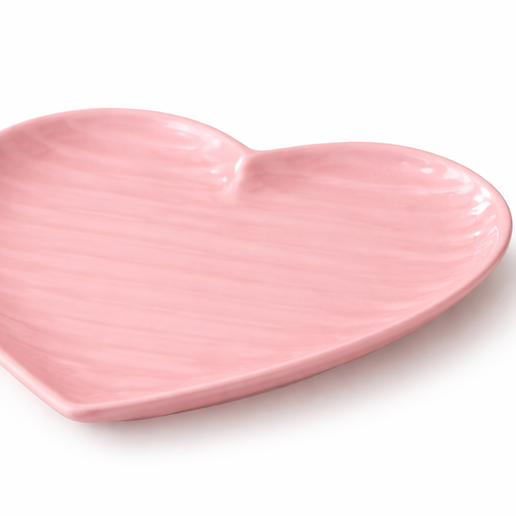 Pink heart-shaped ceramic plate on a white background