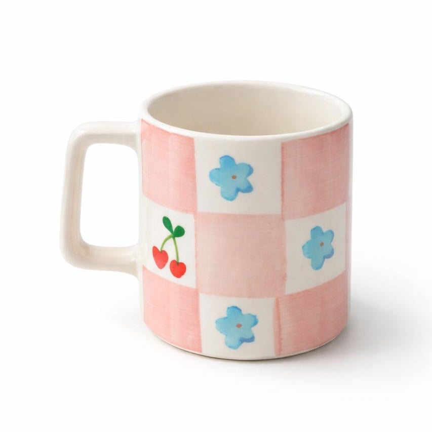 Mug with pink checkered pattern and colorful graphics on a white background