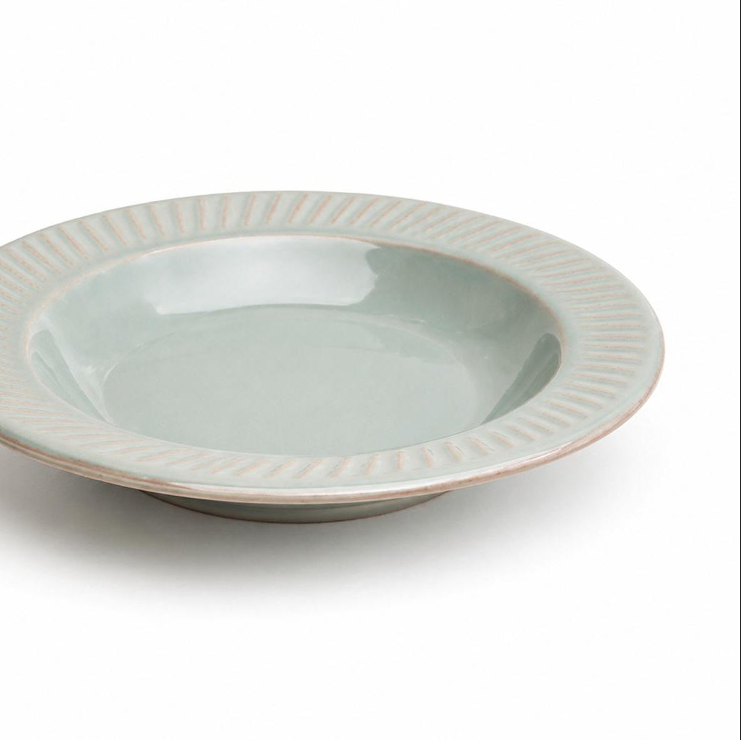 Light blue ceramic bowl with decorative rim on a white background