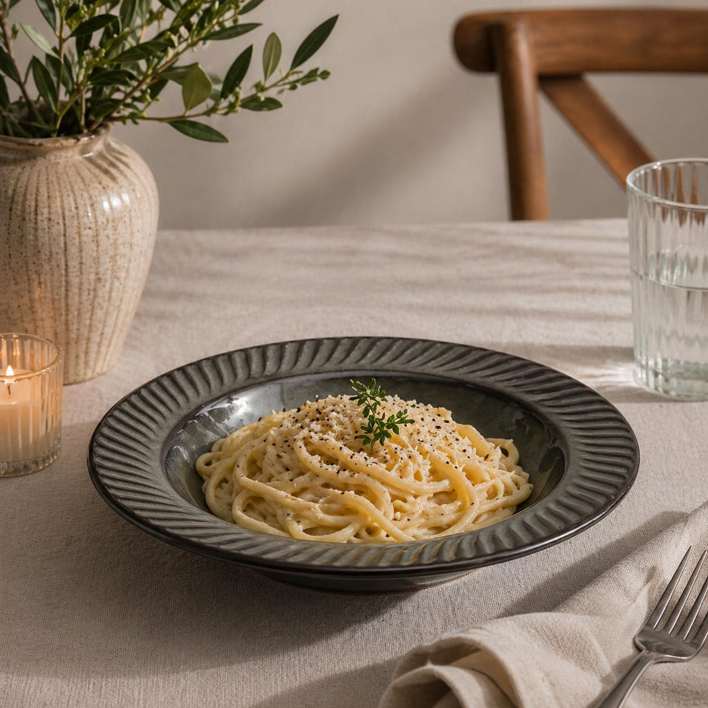 Plate of pasta on a table with a candle and decorative elements