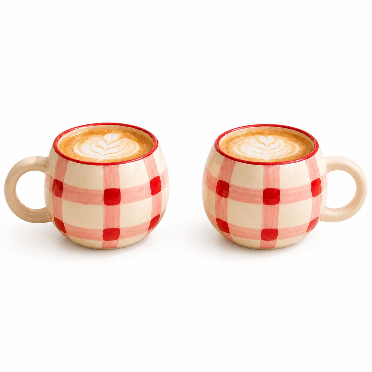 Two checkered mugs with a creamy beverage on a white background