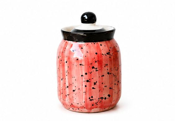 Set of colorful ceramic jars with decorative lids on a white background