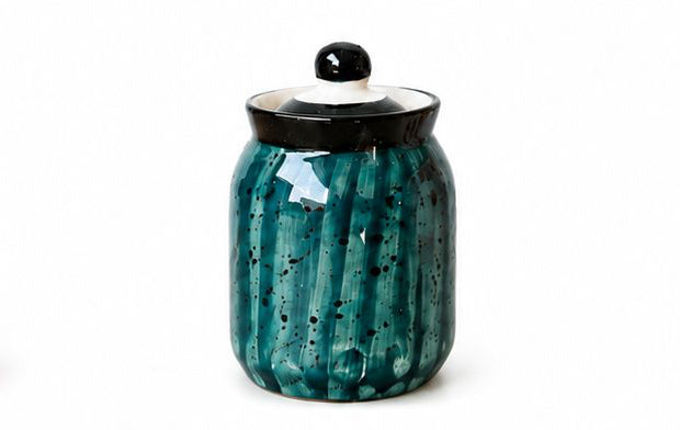 Set of colorful ceramic jars with decorative lids on a white background
