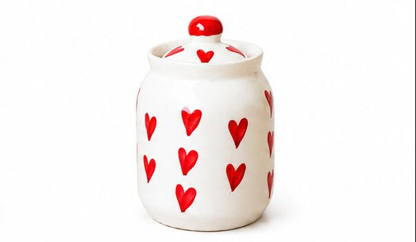 Set of colorful ceramic jars with decorative lids on a white background