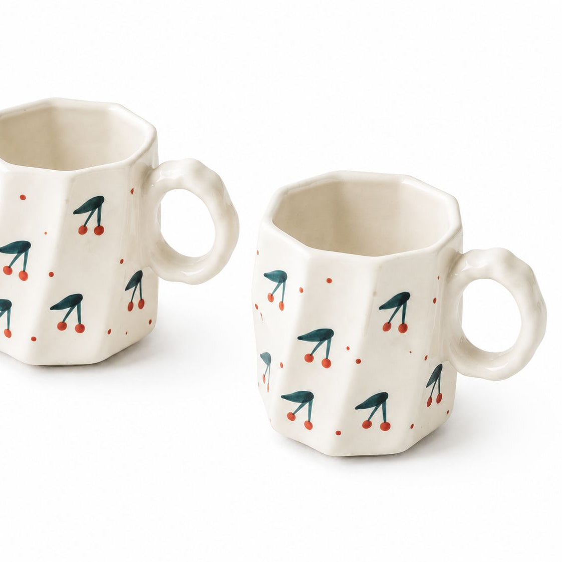 Two ceramic mugs with geometric design on a white background