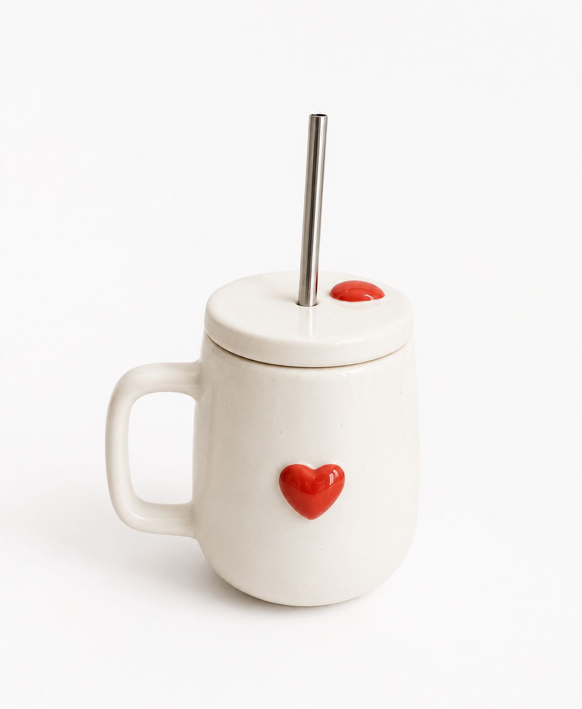 White mug with a red heart design, lid, and straw on a white background