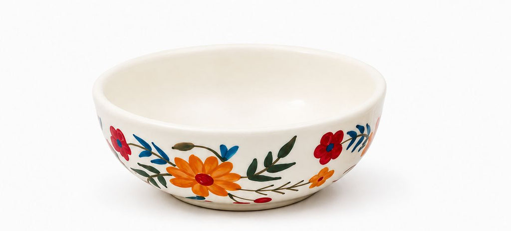 Ceramic cup, saucer, and bowl set with floral design on a white background
