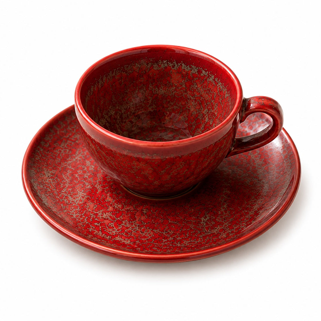 Red ceramic cup and saucer set on a white background