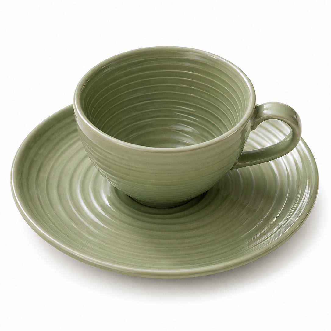 Green ceramic cup and saucer on a white background
