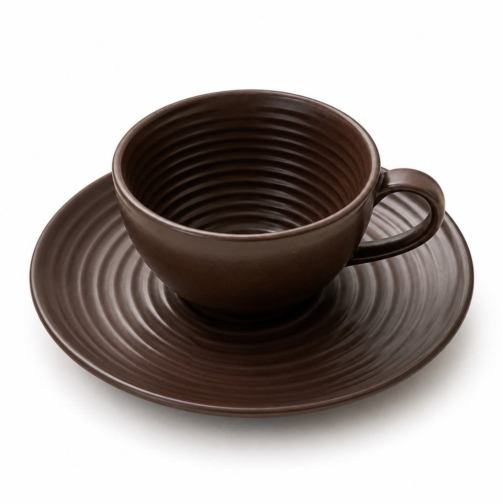 Brown ceramic cup and saucer on a white background