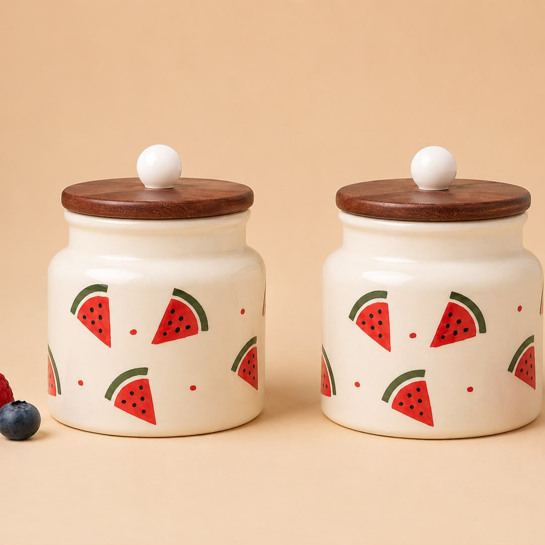 Two ceramic jars with watermelon pattern lids on a beige background