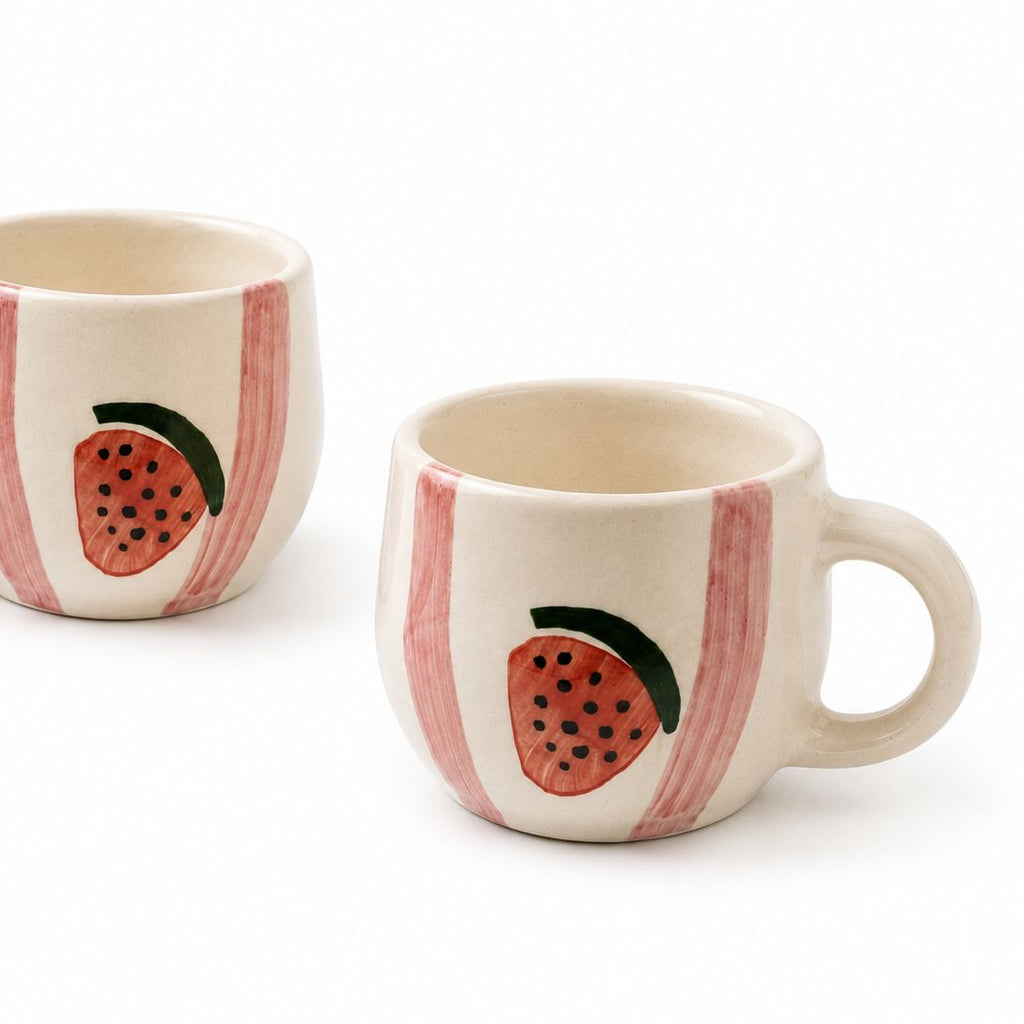Two ceramic mugs with strawberry design on a white background