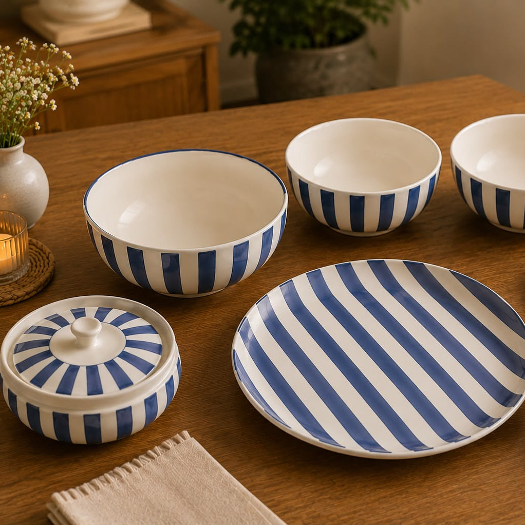 Set of blue and white striped ceramic dishes on a wooden table.