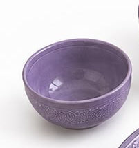 Set of purple ceramic dishes including bowls and plates on a white background